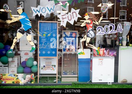 Der Tesco Supermarkt in Wimbledon Village hat sein Fenster in der zweiten Woche der Meisterschaft der All England Lawn Tennis Association am 9. Juli 2024 in Wimbledon, London, England, mit einem Tennisthema verkleidet. Stockfoto