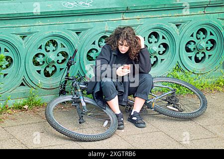 Glasgow, Schottland, Großbritannien. 10. Juli 2024: Wetter in Großbritannien: Sonnig und bewölkt in der Stadt, als Einheimische und Autofahrer das westliche Ende der Stadt durchstreifen. Credit Student und Fahrrad auf der Kelvin-Brücke über den Fluss Kelvin Gerard Ferry/Alamy Live News Stockfoto