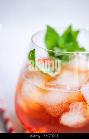 Ein Blick aus der Nähe auf einen erfrischenden Cola-Cocktail, wunderschön garniert mit frischen, lebhaften Minzblättern. Das Getränk wird in einem durchsichtigen Glas serviert Stockfoto