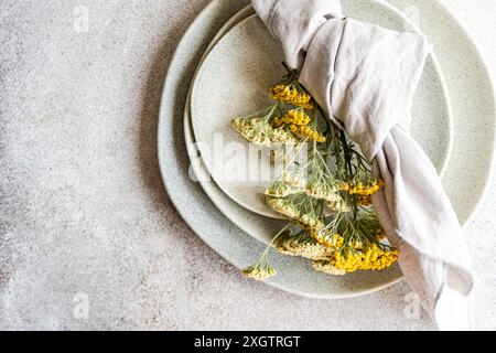 Ein eleganter Sommertisch mit frischen wilden achillea-Blumen im rustikalen Stil, neutralen Keramikplatten und einem Klassiker Stockfoto