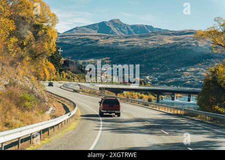 Autotour auf Asphaltstraße mit gelben Waldbäumen im Herbst auf der Südinsel Neuseelands Stockfoto
