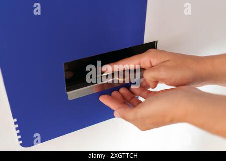 Frauenhände sammeln Münzen an einem Geldwechselautomaten Stockfoto