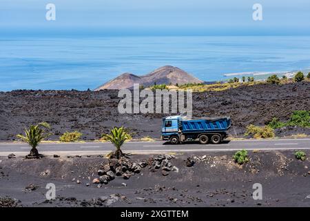 Lkw fährt auf einer Straße, die die vulkanische Landschaft der Insel La Palma, Kanarische Inseln, durchquert. Stockfoto
