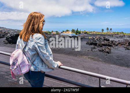 Touristen-Frau, die die vulkanische Mondlandschaft betrachtet, die sich auf der Insel La Palma, den Kanarischen Inseln, gebildet hat. Stockfoto