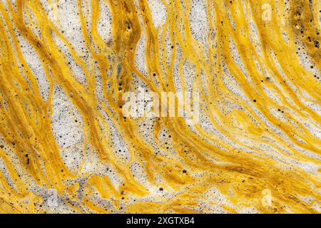 Pulsierende Luftlandschaft aus fließenden gelben Mineralvorkommen und schaumigen Blasen in der Mine Riotinto in Huelva, Spanien, die die Kunstfertigkeit der Natur in in zeigt Stockfoto