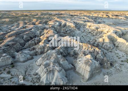 Weitläufige Luftaufnahme, die die mehrschichtigen Strukturen und die verschiedenen Formationen der Bisti Badlands während eines Sonnenuntergangs einfängt und die natürliche Schönheit und unterstreicht Stockfoto