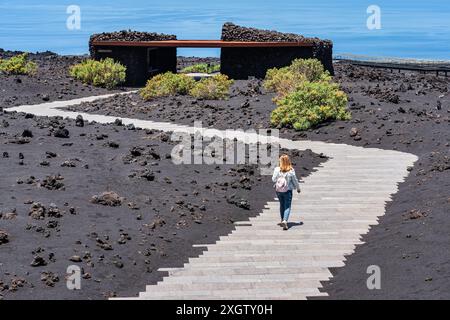 Touristenfrau, die auf einem Pfad zwischen Felsen und Vulkanasche auf der Insel La Palma, Kanarischen Inseln, spaziert. Stockfoto