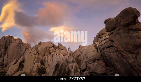 Der bezaubernde Abendhimmel wirft warme Farbtöne über die einzigartigen Granitformationen von La Pedriza, die sich in den Guadarrama-Bergen in der Nähe von Madrid befinden Stockfoto