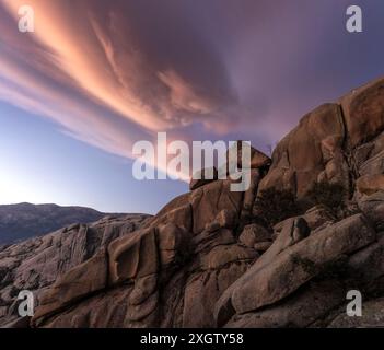 Dramatische Sonnenuntergangswolken stürzen über die einzigartigen Felsformationen von La Pedriza, die in den Bergen von Guadarrama in der Nähe von Madrid liegen Stockfoto