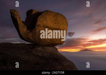 Dramatischer Sonnenuntergang, der die einzigartigen geologischen Felsformationen in La Pedriza beleuchtet, mit einer auffälligen Silhouette vor einem farbenfrohen Himmel Stockfoto