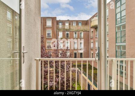 Ein ruhiger Blick von einem Balkon mit Blick auf den Innenhof mit Wohngebäuden, die von Balkonen und Fenstern in der Joan Melchior Kemperstraat verziert sind, Stockfoto