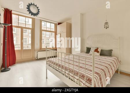 Ein modernes und luftiges Schlafzimmer mit großen Fenstern, minimalistischem Design und einem Hauch von Farbe von roten Vorhängen in Joan Melchior Kemperstraat, Stockfoto