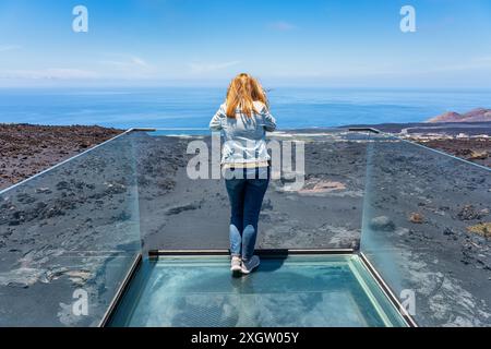 Weibliche Touristen, die die Wüste und Vulkanlandschaft von einem Aussichtspunkt auf der Insel La Palma, Kanarische Inseln, betrachten. Stockfoto