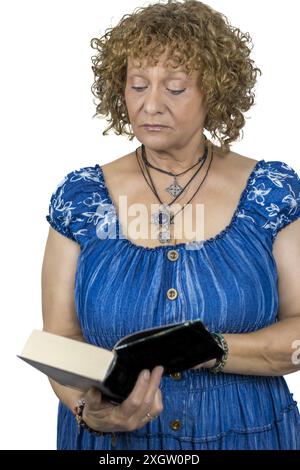 Das Bild zeigt eine 60-jährige Frau, die vor weißem Hintergrund steht. Stockfoto