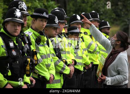 Leicester, Leicestershire, Großbritannien. Juli 2024. Polizisten bilden am Eingang der Fabrik eine Absperrung, während ein Demonstrant auf Arbeiter zeigt, die während der Demonstration arbeiten. Demonstranten versammeln sich vor den Toren der Fabrik von Elbit System in Leicester, um zu protestieren, während Arbeiter bei der israelischen Rüstungsfirma arbeiten. Die Demonstranten protestieren gegen die Waffen, die in dieser Fabrik hergestellt wurden, die ihrer Meinung nach später zur Unterdrückung der Palästinenser in Gaza und anderswo eingesetzt werden. 85 % der israelischen Drohnenflotte werden von Elbit Systems beliefert, und die Demonstranten wollen, dass ihre sieben verbleibenden Unternehmen geschlossen werden Stockfoto