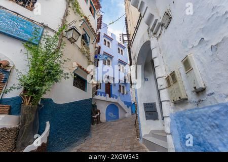 Chefchaouen, Marokko - 25. März 2024: Eine malerische Gasse mit blau-weißen Gebäuden. Die Stadt ist bekannt für ihre blau getünchten Mauern und charmanten Labyrin Stockfoto