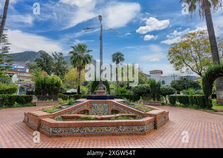 Reich verzierte Brunnen mit traditionellen Mosaiken im Chefchaouen Park mit den Rif Mountains als Kulisse. Ruhige Atmosphäre, Marokko. Stockfoto