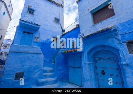 Unter klarem Himmel sind die Chefchaouen-Gassen ein Labyrinth aus Wänden und Treppen in verschiedenen Blautönen. Chefchaouen, Marokko. Stockfoto