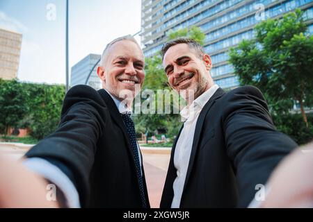 Zwei reife, gut gekleidete Geschäftsmänner machen ein Selfie-Porträt mit freundlichem Ausdruck. Unternehmenspartner, Rechtsanwälte, Vertreter, Finanzverkäufer, Buchhalter oder Manager, die in die Kamera schauen. Hochwertige Fotos Stockfoto