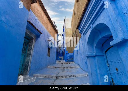 Unter klarem Himmel sind die Chefchaouen-Gassen ein Labyrinth aus Wänden und Treppen in verschiedenen Blautönen. Chefchaouen, Marokko. Stockfoto