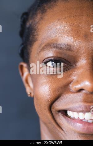 Nahaufnahme einer Afroamerikanerin, die lächelt, mit Kopierraum. Ihr fröhlicher Ausdruck verleiht dem Bild eine warme, persönliche Note. Stockfoto