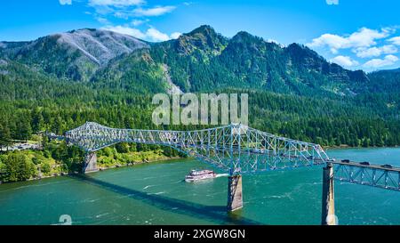 Die Brücke der Götter über dem Fluss mit dem Paddeldampfer in den bewaldeten Bergen Stockfoto