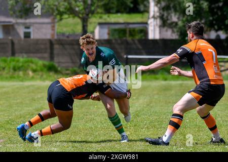 Port Talbot, Wales. 6. Juli 2024. Will Davies von Aberavon Fighting Irish wird von James Raymond von Torfaen Tigers bekämpft, während Rhys Evans von Torfaen Tigers während des Spiels der JES Group Rugby League zwischen Aberavon Fighting Irish und Torfaen Tigers am 6. Juli 2024 beim Aberavon Harlequins RFC in Port Talbot, Wales, Großbritannien, zusieht. Quelle: Duncan Thomas/Majestic Media. Stockfoto