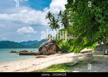 Ein verstecktes, ruhiges Juwel in Penang, ein paradiesischer Reiseort, genannt Secret Beach, wunderschöner Sand und Kokospalmen am Strand, Einheimische Stockfoto