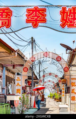 Penang, Malasien-April 30 2023: Dieser kunstvoll verzierte Clan Jetty, dekoriert mit chinesischen Symbolen und gesäumt von Geschäften und Restaurants, ist auf Stelzen gebaut, am Rande von Stockfoto