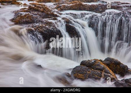 Kaskadierender Wasserfall über Moosfelsen lange Exposition aus erhöhtem Winkel Stockfoto