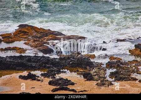 Die rauen Wellen der Küste von Oregon stürzen auf Flechten-Covered Rocks Aerial View Stockfoto