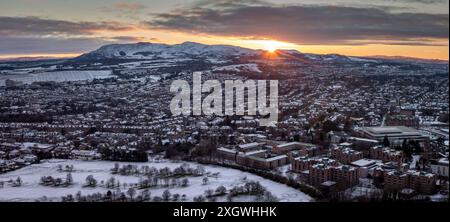 Blick auf Edinburgh, bedeckt mit Schnee von der Spitze des Arthurs Seat mit Sonnenaufgang hinter den Pentland Hills Stockfoto