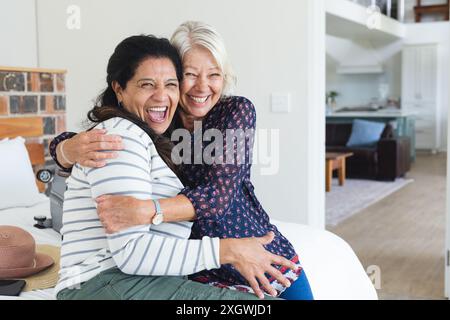 Porträt von zwei aufregenden, verschiedenen älteren Freundinnen, die sich im Ferienhaus umarmen, Kopierraum. Freundschaft, Urlaub, Reisen und aktiver Lebensstil der Senioren Stockfoto