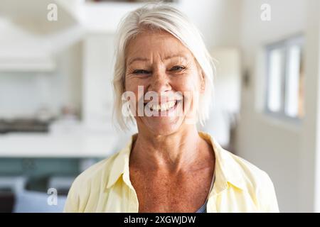 Porträt einer glücklichen älteren kaukasischen Frau mit weißem Haar, die zu Hause lächelt. Wohlbefinden, häusliches Leben und Lebensstil der Senioren, unverändert. Stockfoto