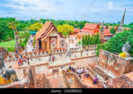 AYUTTHAYA, THAILAND - 5. MAI 2019: Wat Yai Chai Mongkhon mit riesigen Statuen von Buddha, Ubosot, geschnitzten Chedis, Schreinen und grünem Garten, am 5. Mai in Ay Stockfoto