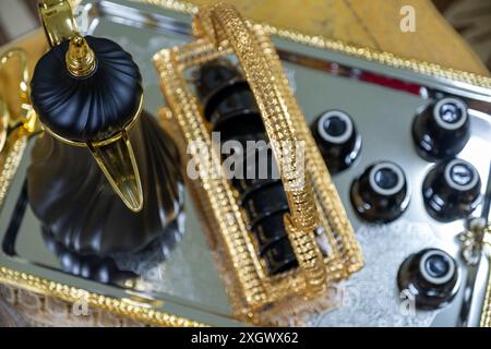 Schwarzer Hochglanzkaffee auf metallischem und goldenem Tablett für Feiertage und Familientreffen Stockfoto