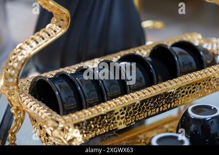 Schwarzer Hochglanzkaffee auf metallischem und goldenem Tablett für Feiertage und Familientreffen Stockfoto