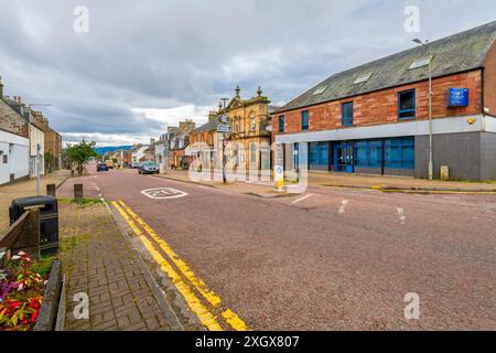 Die historische High Street, die Hauptstraße mit Geschäften, Cafés und Geschäften durch die Hafenstadt Invergordon, Schottland. Stockfoto