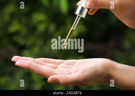 Frau tropft im Freien ätherisches Öl aus der Pipette, Nahaufnahme Stockfoto