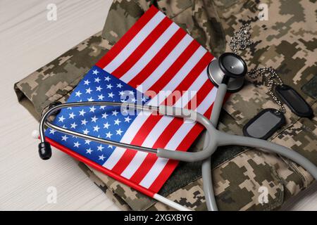 Stethoskop, US-Flagge, Tags und Militäruniform auf weißem Holztisch Stockfoto