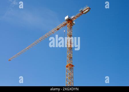 Gelber Baukran gegen den blauen Himmel Stockfoto