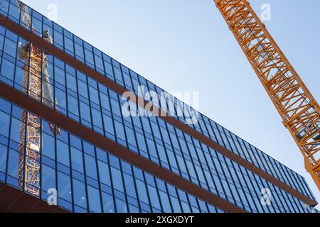 Reflexion des Baukrans in modernen Bürofenstern Stockfoto