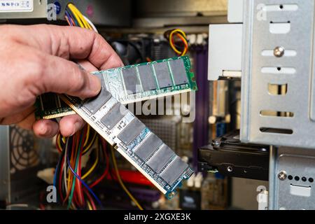 Eine Hand eines Technikers, der die RAM-Speicherbank eines Computers zeigt. Stockfoto