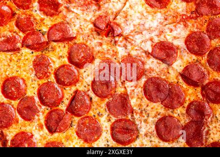 Eine Aussicht von oben auf eine rustikale Peperoni-Pizza mit Scheiben. Stockfoto