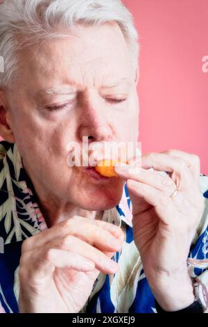 Senior-Mann, der Cheetos knabbert und ein Chaos macht, 2024, USA Stockfoto