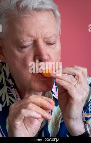 Senior-Mann, der Cheetos knabbert und ein Chaos macht, 2024, USA Stockfoto