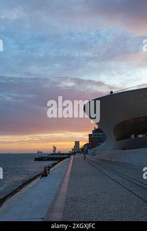 Das Ufer des Tejo bei Sonnenuntergang mit dem MAAT-Museum auf der rechten Seite und dem Padrão dos Descobrimentos am Horizont - Lissabon, Portugal. Stockfoto