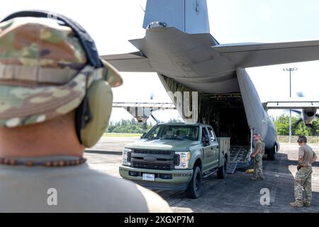 Die US-Luftstreitkräfte mit der 156th Contingency Response Group, Puerto Rico Air National Guard und mit dem 136th Contingency Response Flight, Texas Air National Guard, laden einen Pick-up-Truck auf ein C-130J Flugzeug während eines gemeinsamen Lufthafentrainings auf der Muñiz Air National Guard Base, Carolina, Puerto Rico, 27. Juni 2024. Während der Ausbildung führten die 156. CRG und die 136. CRF Motoren aus, die auf-/Entladeszenarien betrieben werden, und bereiteten multifähige Luftstreitkräfte vor, um in einer simulierten, feindlichen Umgebung zeitnahe Ladungseinsätze durchzuführen, um ihre Bereitschaft für künftige schnelle Mobilitätsmissionen zu verbessern. (U.S. Air Na Stockfoto