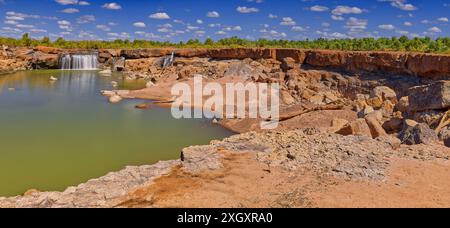 Panorama der Leichhardt Falls Tauchen Sie den Wasserfall über rote Felsen mit grünem Pool sonnigen Tag blauen Himmel, Golf von Carpentaria, Queensland, Australien Stockfoto