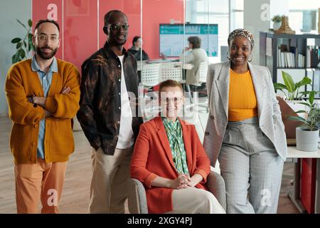 Porträt von vier verschiedenen Kollegen, die sich im Amt ausgeben und Selbstvertrauen und Professionalität zeigen. Zu den Teammitgliedern gehören Kaukasier, Schwarze und multirassische Personen, die Inklusivität vertreten Stockfoto